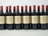 six bottles of red wine lined up in a row on a table
