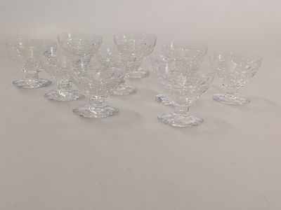 several clear wine glasses are lined up on a white surface