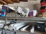 many rolls of paint and rolls of paper on a shelf
