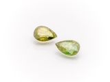 a pair of green tourmaline gems on a white background