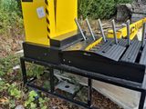 a yellow box sitting on top of a metal cart next to a forest