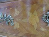 two metal handles on a wooden cabinet with flowers on it