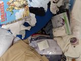 a pile of clothes and other items on a bed