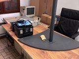 un homme debout devant un bureau sur lequel se trouve un ordinateur