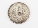 a silver coin on a white surface with a chinese writing on it