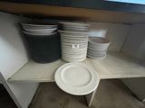 many plates and bowls on a shelf in the kitchen