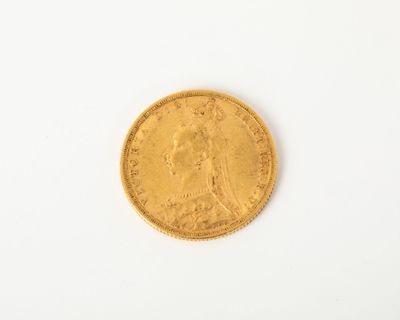 gros plan d'une pièce d'or sur une surface blanche