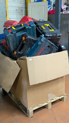 une caisse remplie d'outils posée sur une palette dans un entrepôt