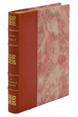 un vieux livre à la couverture rouge posé sur une surface blanche