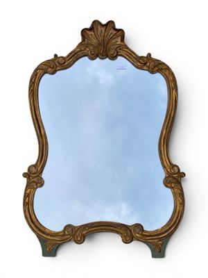 an ornately carved mirror with a blue sky in the background