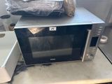 a microwave sitting on top of a counter with a bag on top of it