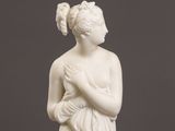 a white statue of a woman holding a bird in her hands
