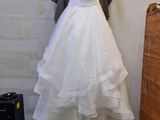 a wedding dress hanging on a hanger in a room
