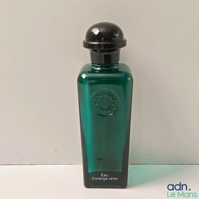 un flacon de parfum posé sur une surface blanche