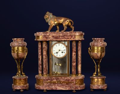 une horloge surmontée d'un lion, à côté de deux vases