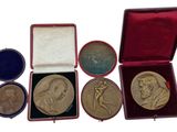 four medals in a red case sitting on top of a white surface