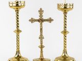 two gold candles are sitting next to each other on a white surface