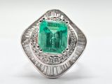 an emerald and diamond ring on a white background