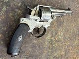 un vieux pistolet posé par terre sur une surface sale