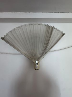 un ventilateur blanc accroché au mur dans une pièce
