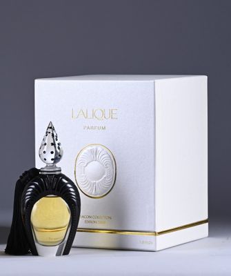a close up of a bottle of perfume next to a box