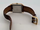an image of a watch on a white surface with a brown strap