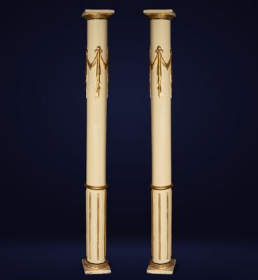 a pair of gold and white columns with an egyptian design