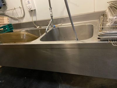 un évier en acier inoxydable dans une cuisine équipée d'un robinet en métal