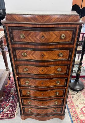 une commode ancienne dans une pièce où se trouve un tapis au sol