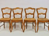 four wooden chairs are lined up against a white background