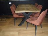 a wooden table with chairs around it in a room