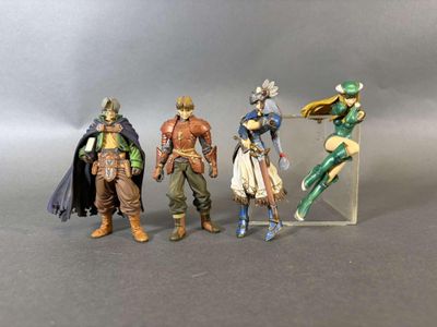 trois figurines représentant différents personnages sont disposées sur une surface grise