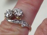 a woman ' s hand with a diamond ring on it