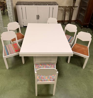 a white table with six chairs around it in a room