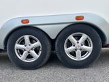 a close up of the wheels of a white trailer