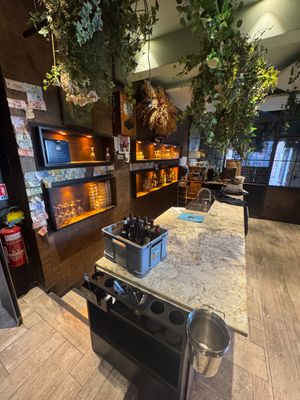 a kitchen with a stove, oven, sink, and shelves