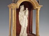 statue d'une femme tenant un enfant dans un cadre en bois