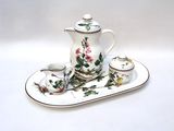 a tea set on a tray with a cup and saucer