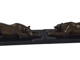 a pair of bronze sculptures of two lions on a black base
