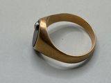 an image of a gold ring with a black stone