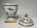 a white bowl with a gold lid next to a white bowl with a gold lid