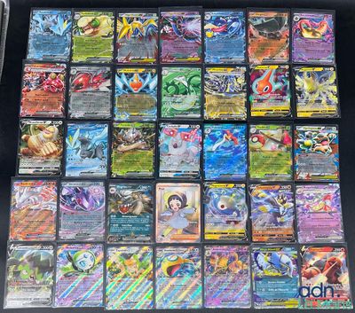 a table topped with lots of different types of pokemon cards