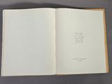 an open book sitting on top of a table next to a gray table