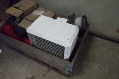 un réfrigérateur blanc posé à l'intérieur d'une caisse en bois