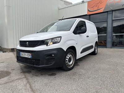 une camionnette blanche garée devant un bâtiment dans un parking
