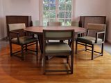 a wooden table with four chairs around it in a room