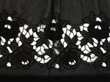 a close up of a black dress with black flowers on it