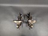 une paire d'appliques murales anciennes sur un mur gris