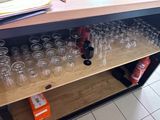 Des bouteilles et des verres sont alignés sur une étagère dans une pièce