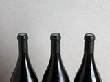 three bottles of wine sitting on top of a table next to each other